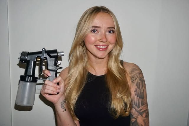 Savanna, owner of Bronzed Behaviour, holding her spray tan gun